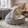 Cama mullida 2 en 1 gris con gatito blanco en dormitorio con luces cálidas
