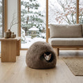 Cama cueva de lana natural Mellow beige con gatito en salón japandi